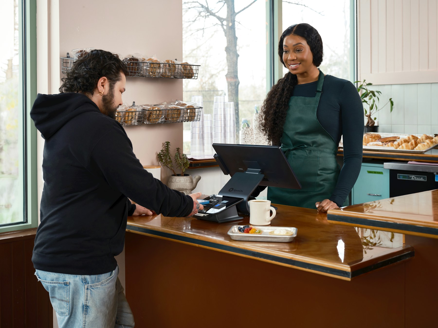 A merchant serving a customer at a cafe counter